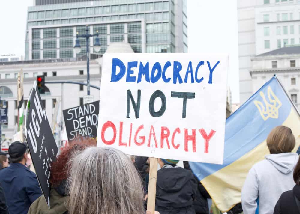 Protest Sign saying "Democracy, not Oligarchy"