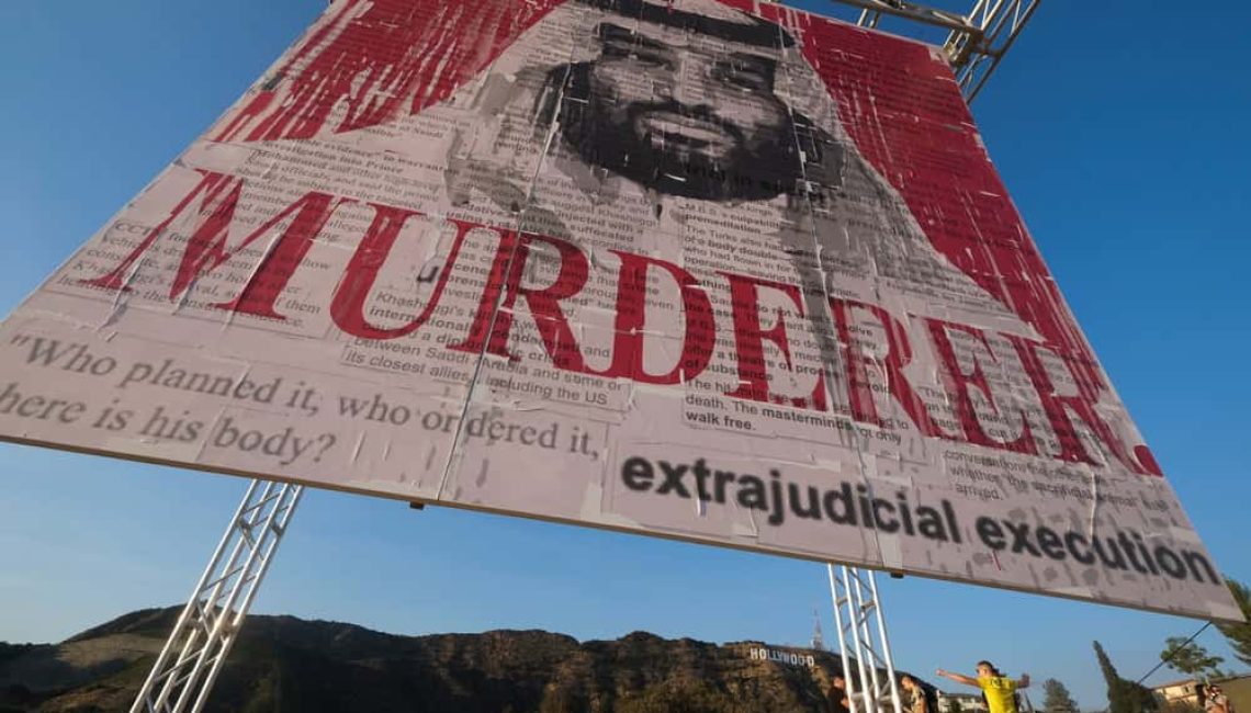 Sign being held up of MBS stating MURDERER